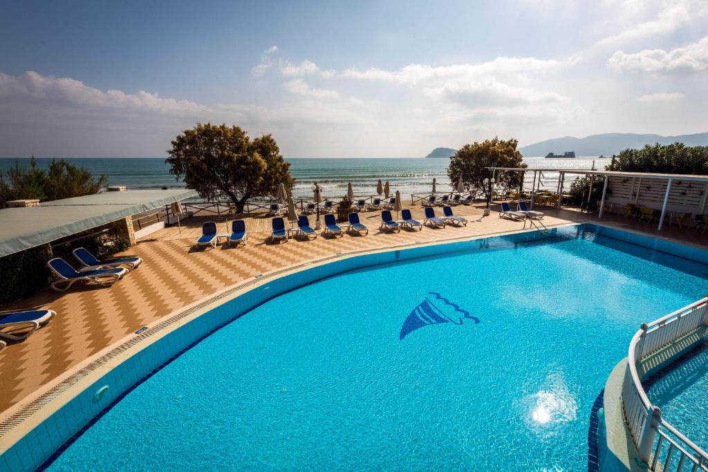 拉加纳斯地中海海滩度假酒店的一个带椅子的游泳池,背景是大海