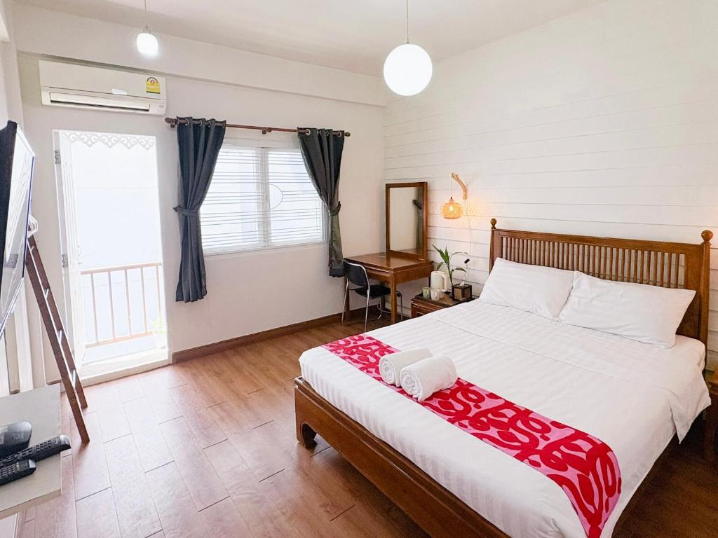 曼谷Les Fleurs Bangkok Hostel的一间卧室，配有一张床、一张书桌和一扇窗户