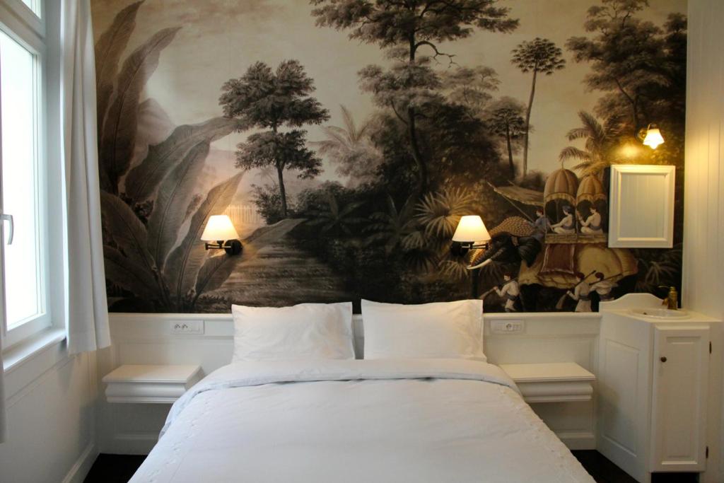 布鲁塞尔莱皮克森特住宿加早餐旅馆的卧室配有壁画和床