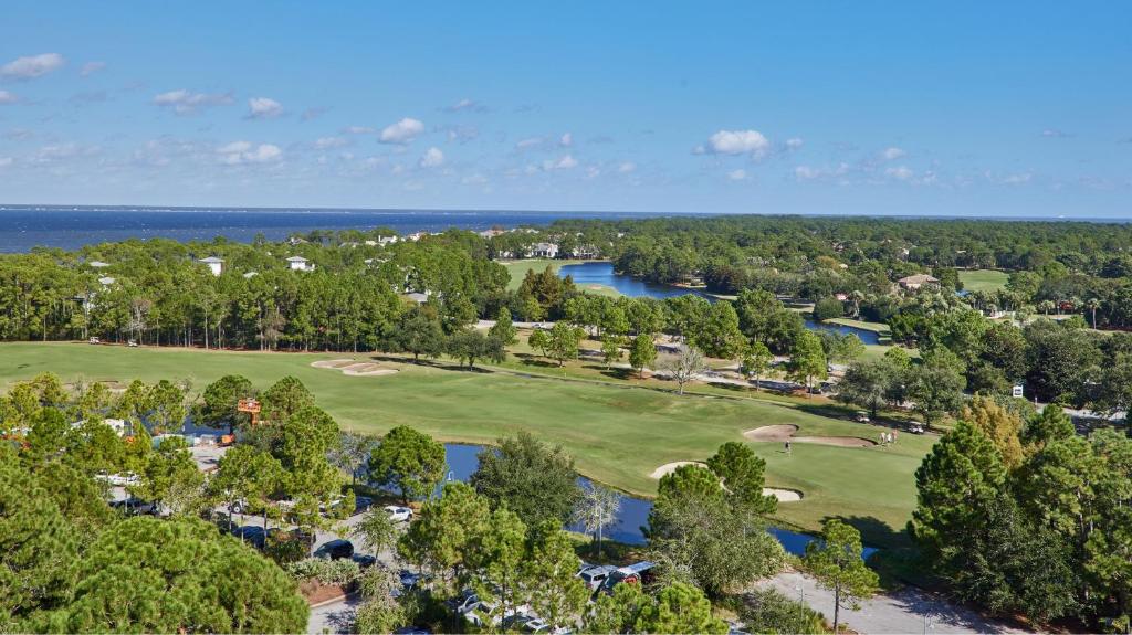 德斯坦Hotel Effie Sandestin Resort, Autograph Collection的享有高尔夫球场的顶部景色,那里有树木和水