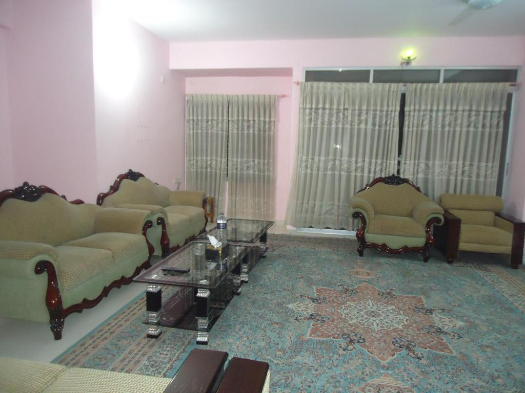 库克斯巴扎Unity Inn的客厅配有两张沙发和一张桌子