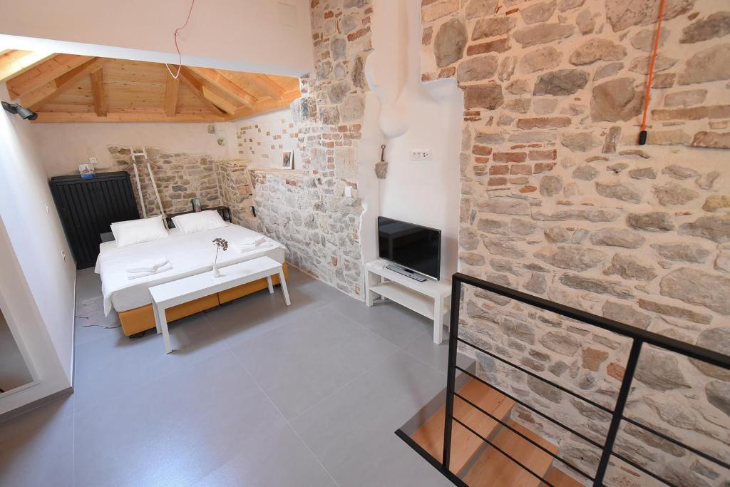 斯普利特铁塔客房旅馆的一间卧室设有一张床和石墙