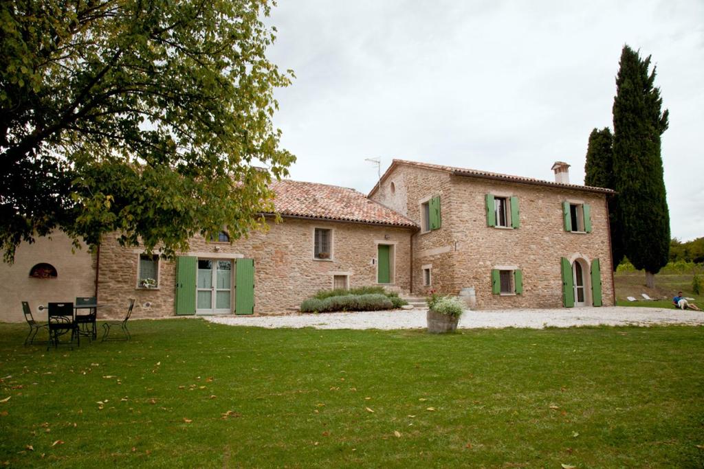 布里西盖拉Azienda Agricola Baccagnano的一座带绿门和庭院的大型石屋
