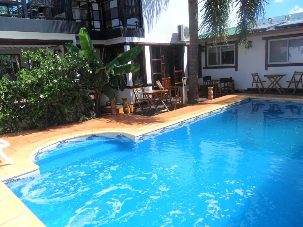 伊瓜苏港Si Mi Capitán - Cabañas & Habitaciones的一座大型蓝色游泳池,位于房子旁边
