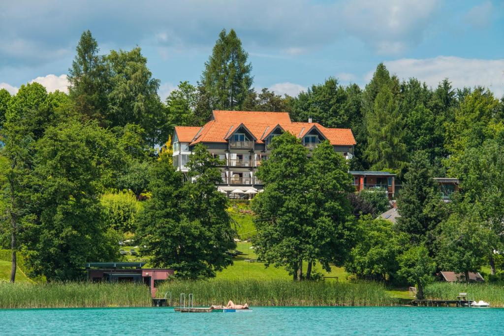 法克湖畔埃格Kleines Hotel Kärnten的湖畔的大房子