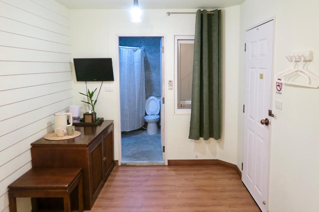 曼谷Les Fleurs Bangkok Hostel的走廊上设有带卫生间的浴室和门