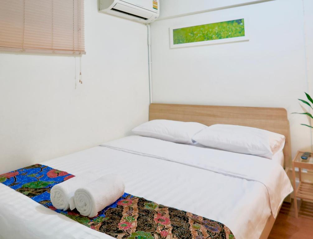 曼谷Les Fleurs Bangkok Hostel的一间卧室设有两张白色的床和窗户