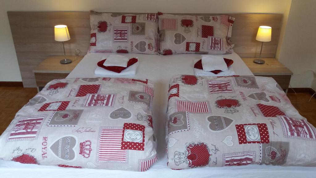 贝卢诺卡萨费南达公寓的两张带红白毯子和枕头的床