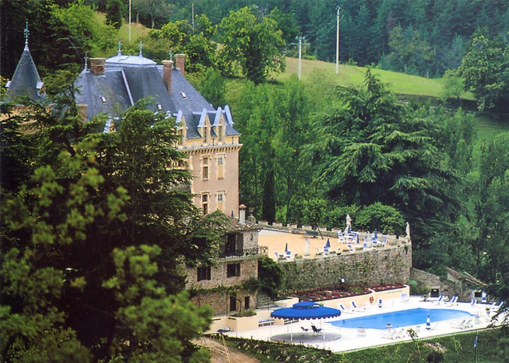 拉马斯特尔尤尔比阿克城堡酒店的一座大型城堡,前面设有一个游泳池