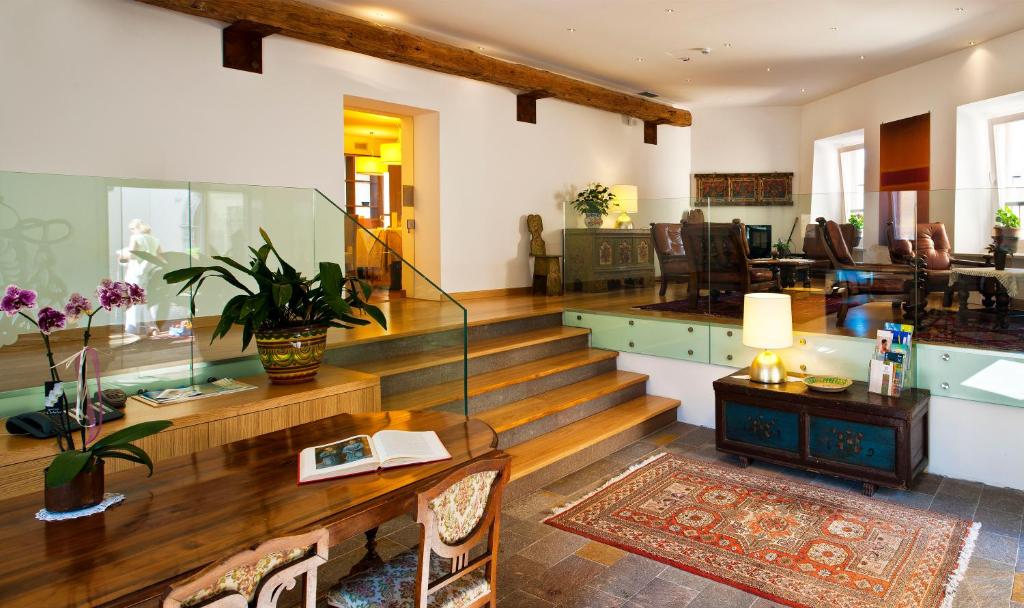 莱维科特尔梅罗曼达酒店的客厅设有楼梯和桌椅
