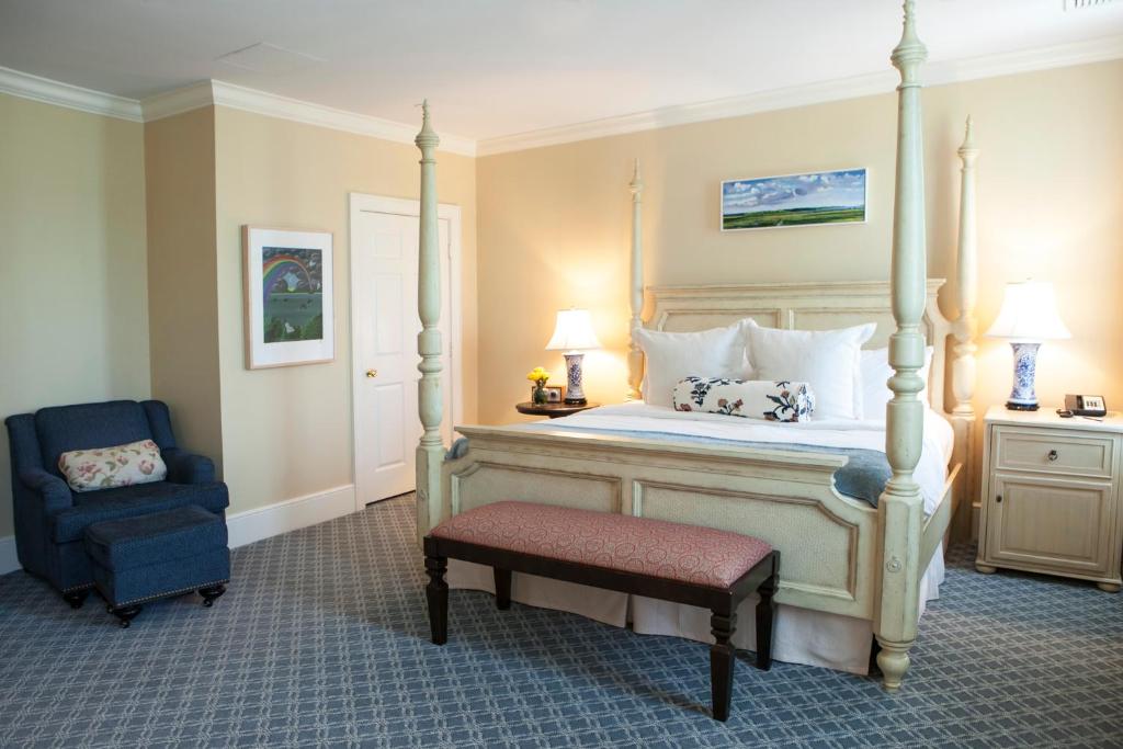 Southport德勒马南港酒店的一间卧室配有一张天蓬床和一把椅子