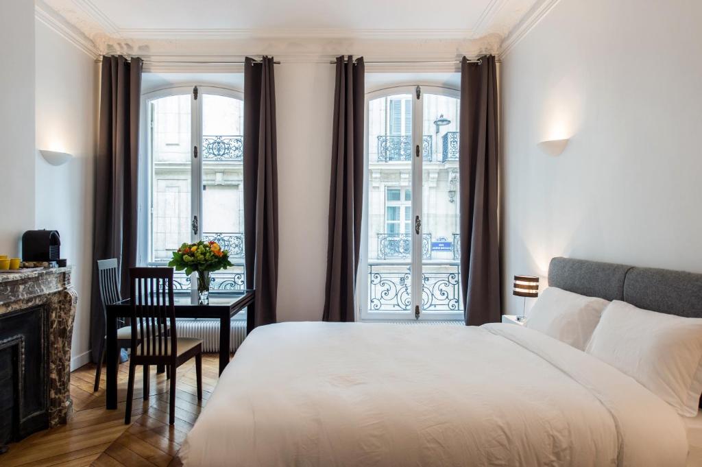 巴黎Paris Square的卧室配有一张床、一张书桌和窗户。