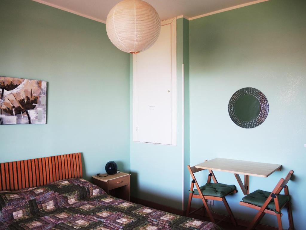 安齐奥乐宁非住宿加早餐旅馆的一间卧室配有一张床、一张桌子和一张桌子