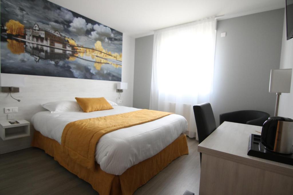 亚眠Logis hôtel - La Chambre D'Amiens的酒店客房设有一张床,墙上挂着一幅大画