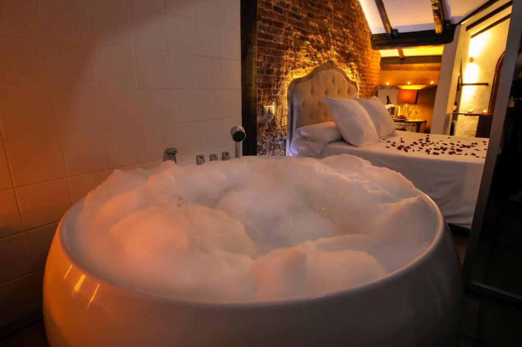 圣拉菲尔Hotel Rural La Viña - Only Adults的配有2张床的客房内配有泡沫浴缸。