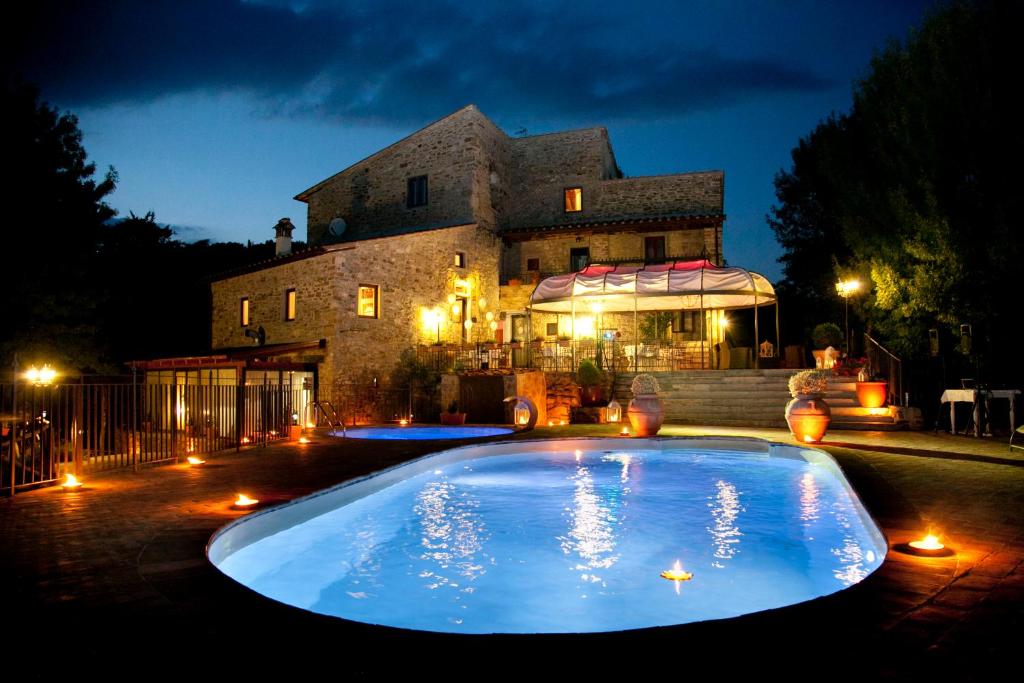 巴贝里诺·迪·穆杰罗Il Castelluccio Country Resort Restaurant & SPA的一座大楼前的大型游泳池