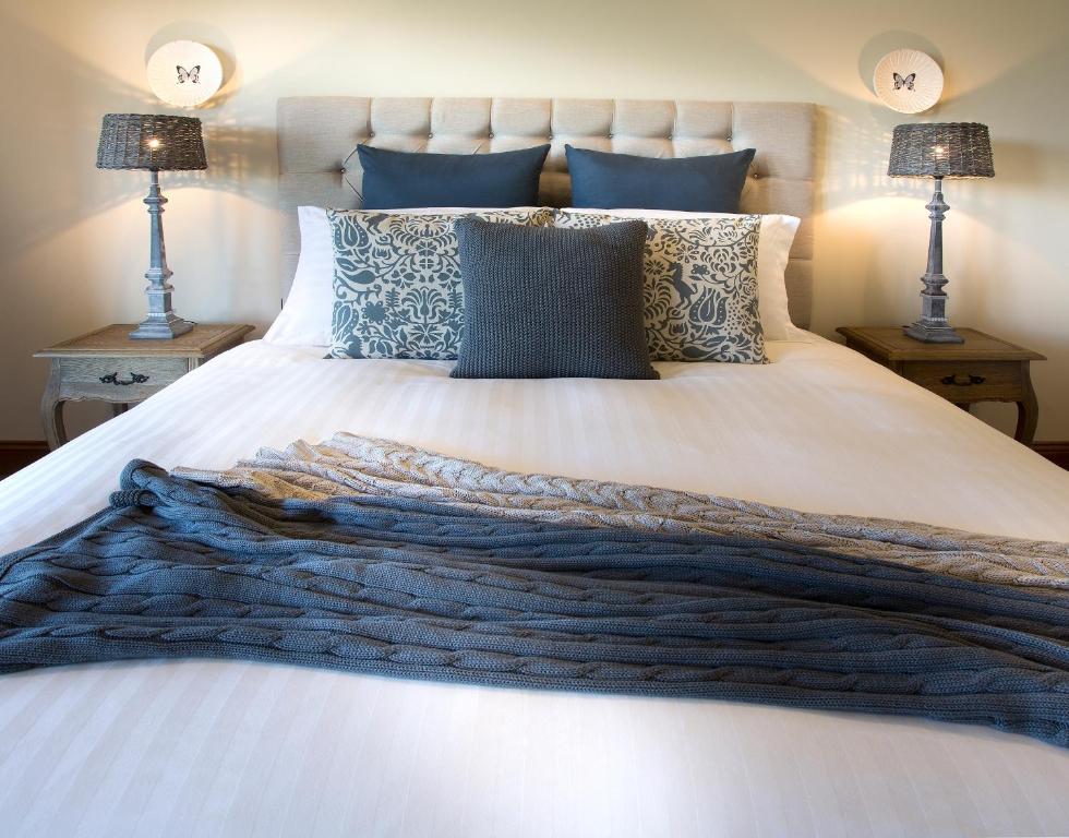 Acheron多姆艾路因住宿加早餐旅馆的卧室配有带蓝色枕头的大型白色床