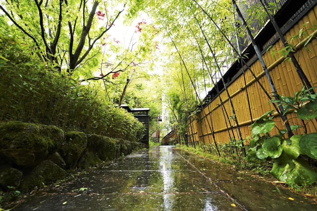日田市风早酒店的一条有栅栏和树木的雨水浸没的道路