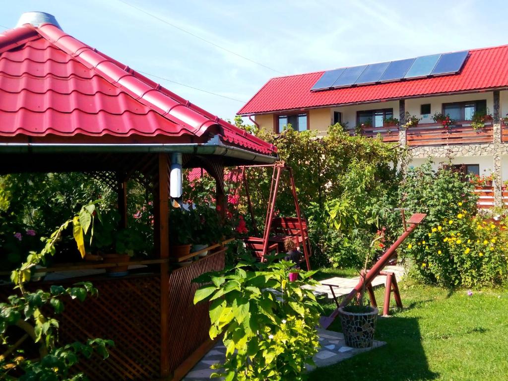 霍雷祖Pensiunea Dana的花园设有凉亭和红色屋顶