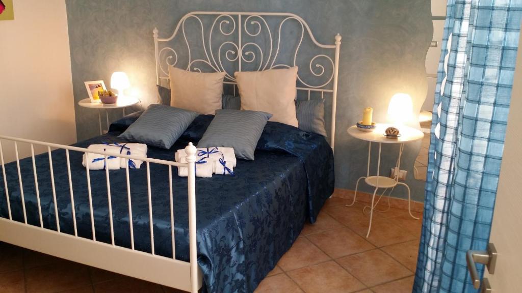 阿格里真托斯嘉丽塔酒店的一间卧室配有一张带蓝色床单和枕头的床。