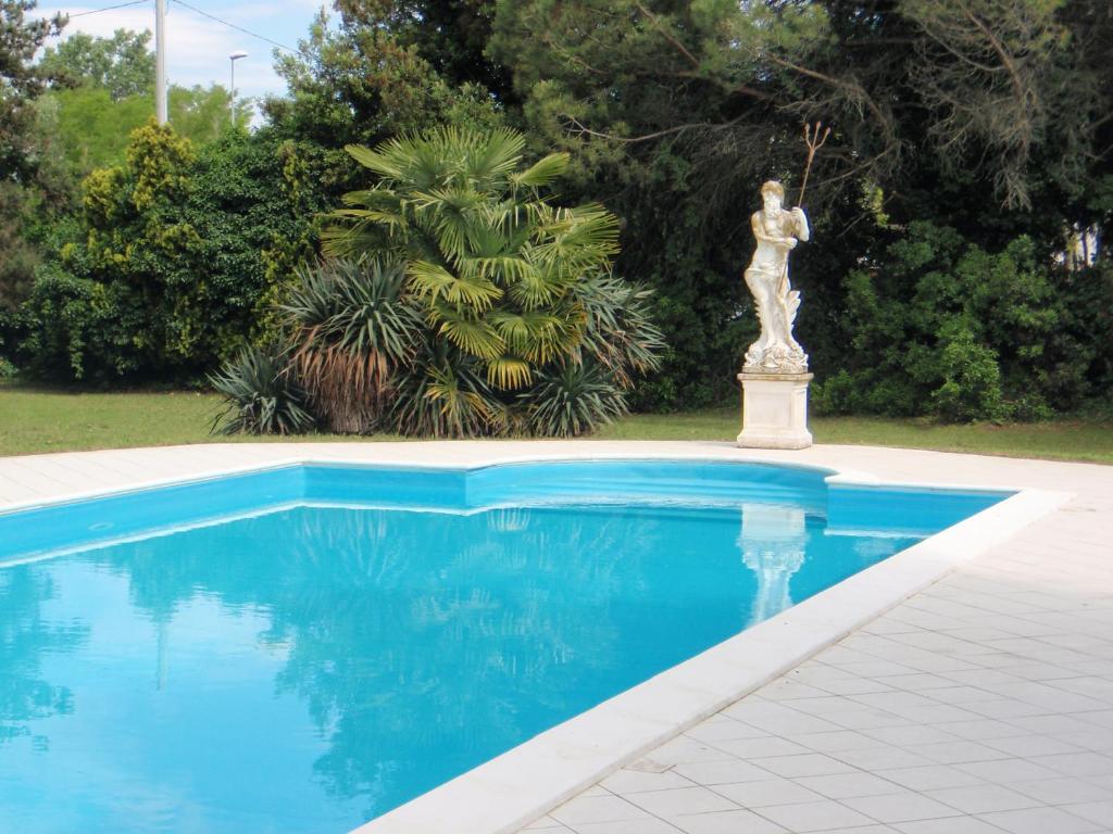 维罗港卡莱尔别墅的蓝色游泳池旁的雕像