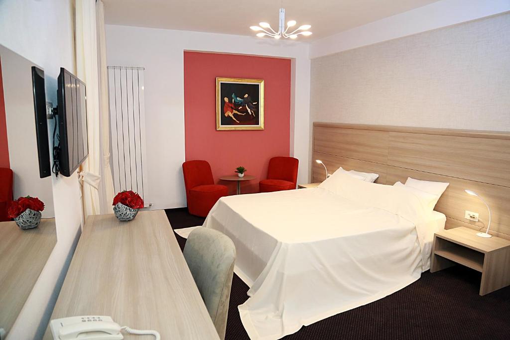 布加勒斯特Parliament Square的酒店客房,设有白色的床和红色的墙壁