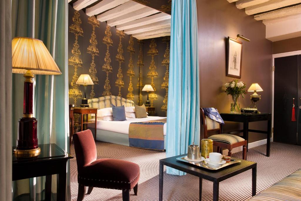 巴黎雷斯当斯艺术酒店的酒店客房带一张床、一张桌子和椅子