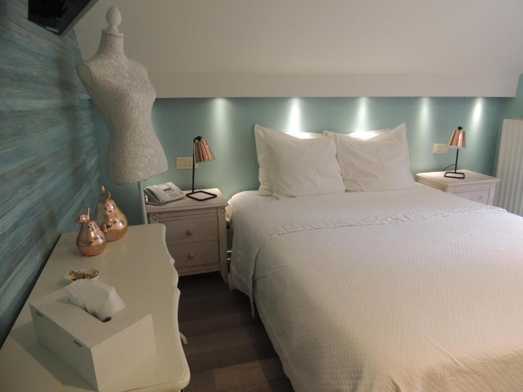 斯帕拉特内勒日酒店的卧室配有白色的床和带梳妆台的床头柜。