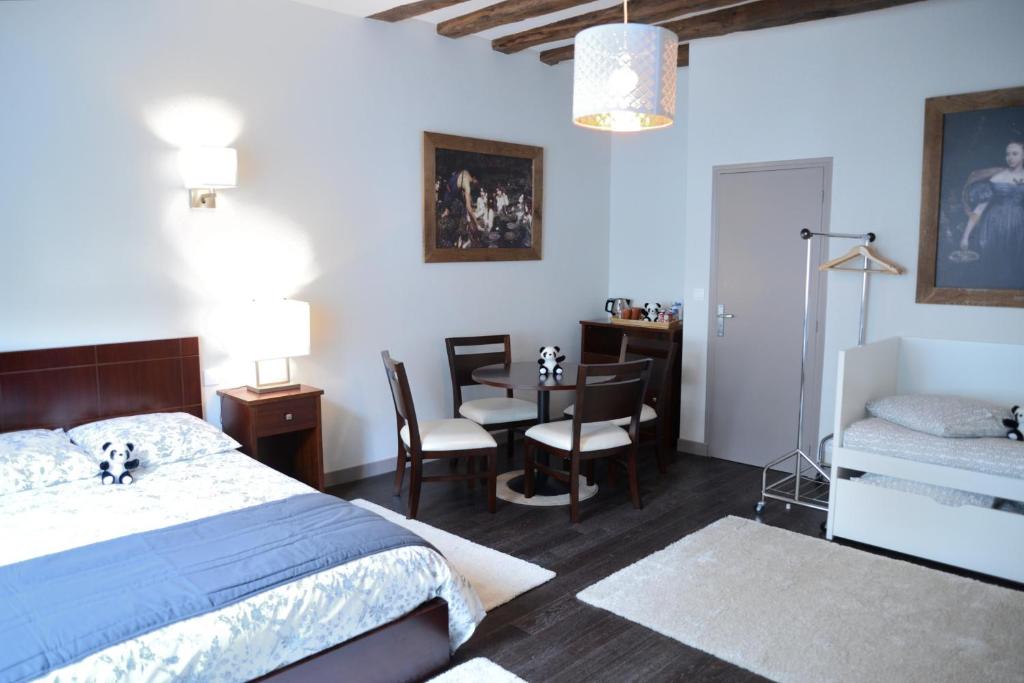 圣艾尼昂Maison du chatelain的卧室配有一张床和一张桌子及椅子