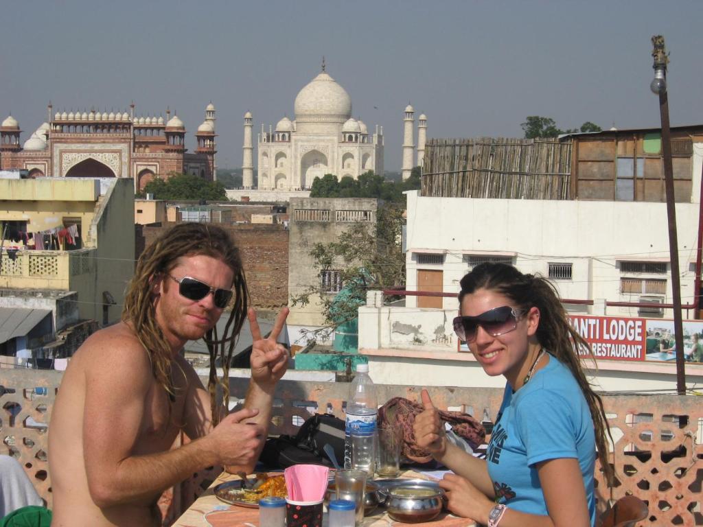 阿格拉Hotel Sai Palace Walking Distance From Taj Mahal--View of Taj Mahal的坐在餐桌旁吃饭的男人和女人