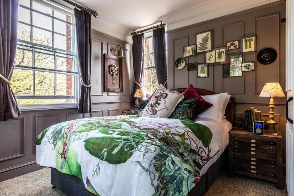 威布里治手和矛旅馆的一间卧室配有一张带五颜六色的被子的床和窗户
