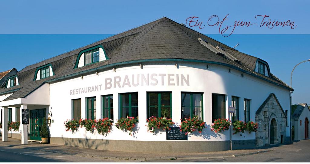 新锡德勒湖畔普巴赫Hotel & Restaurant Braunstein - Pauli´s Stuben的街道上窗户上有鲜花的建筑