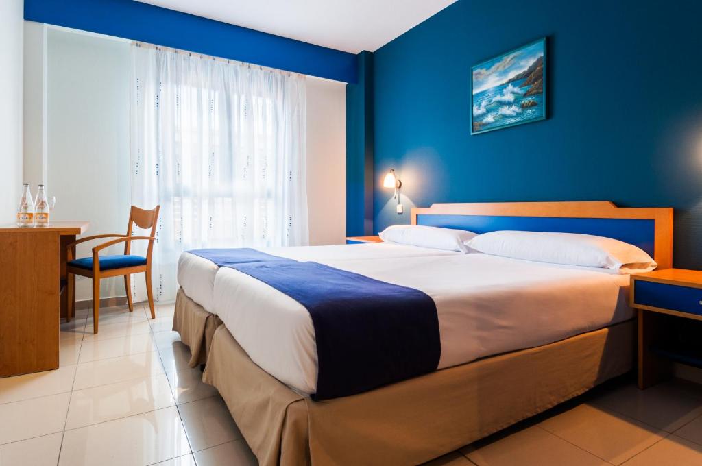 平托Villa De Pinto的一间卧室设有一张蓝色墙壁的大床