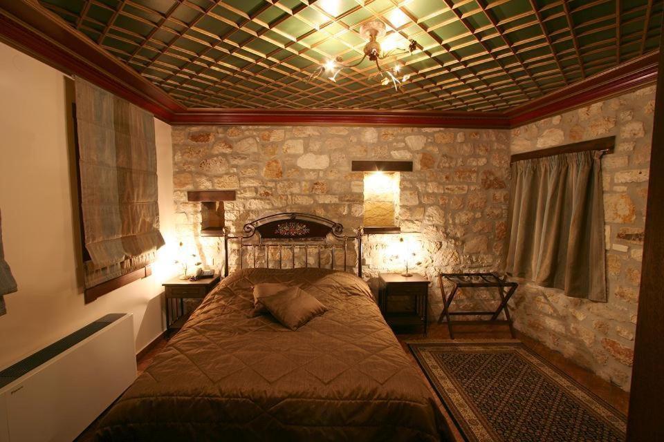 约阿尼纳海格亚替宾馆的石墙客房的卧室配有床