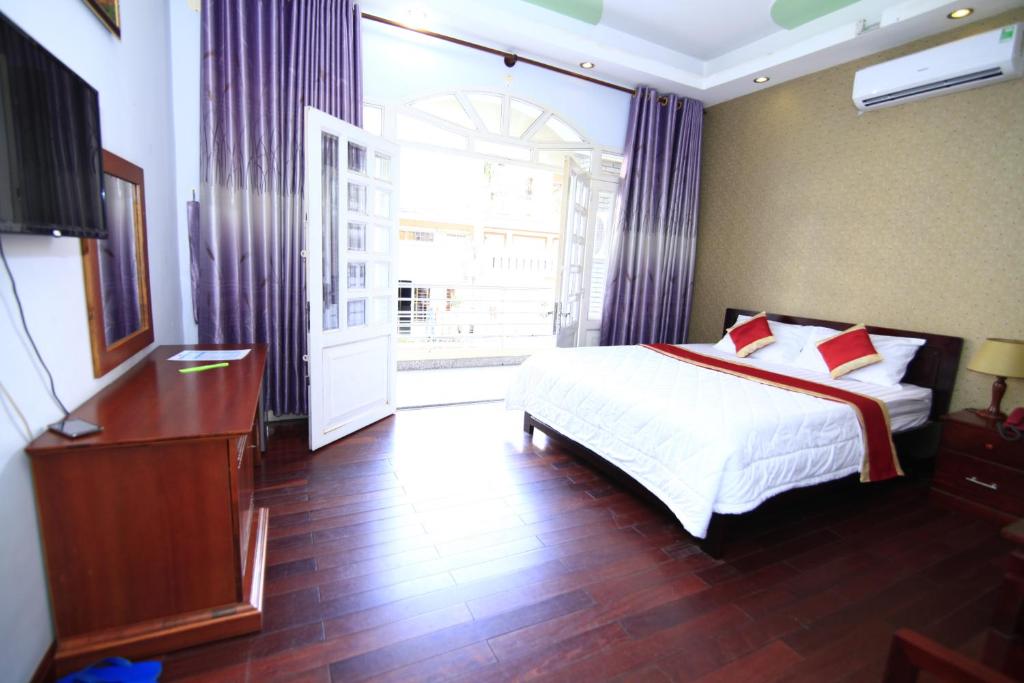 胡志明市张江酒店的一间卧室设有一张床和一个大窗户