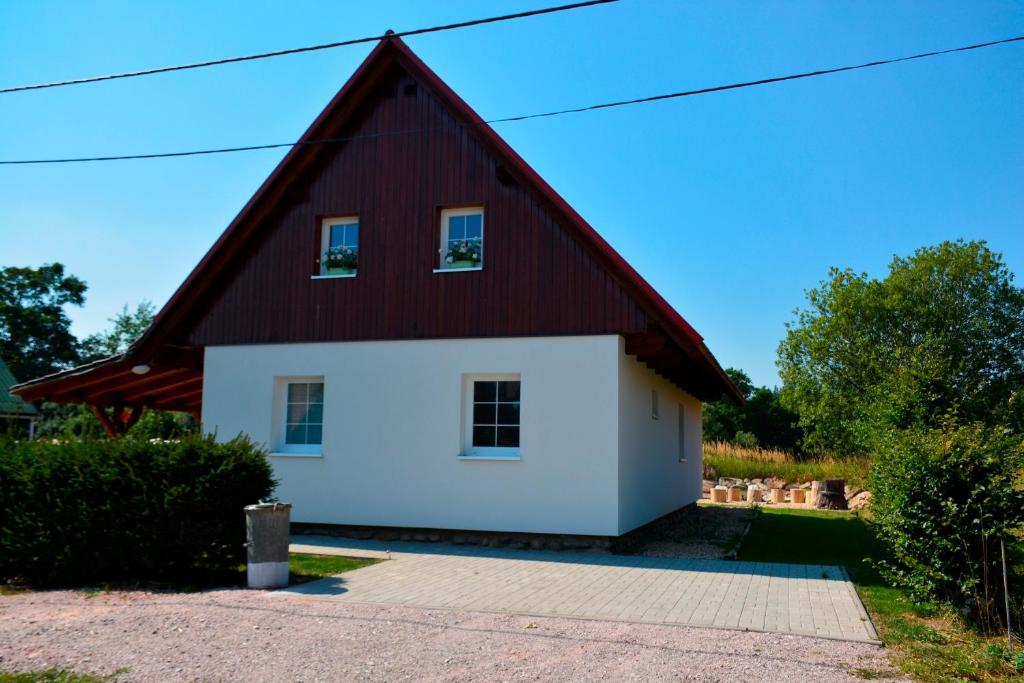 切尔尼杜尔Holiday Home Osada的一座红色屋顶的房子和一个白色车库