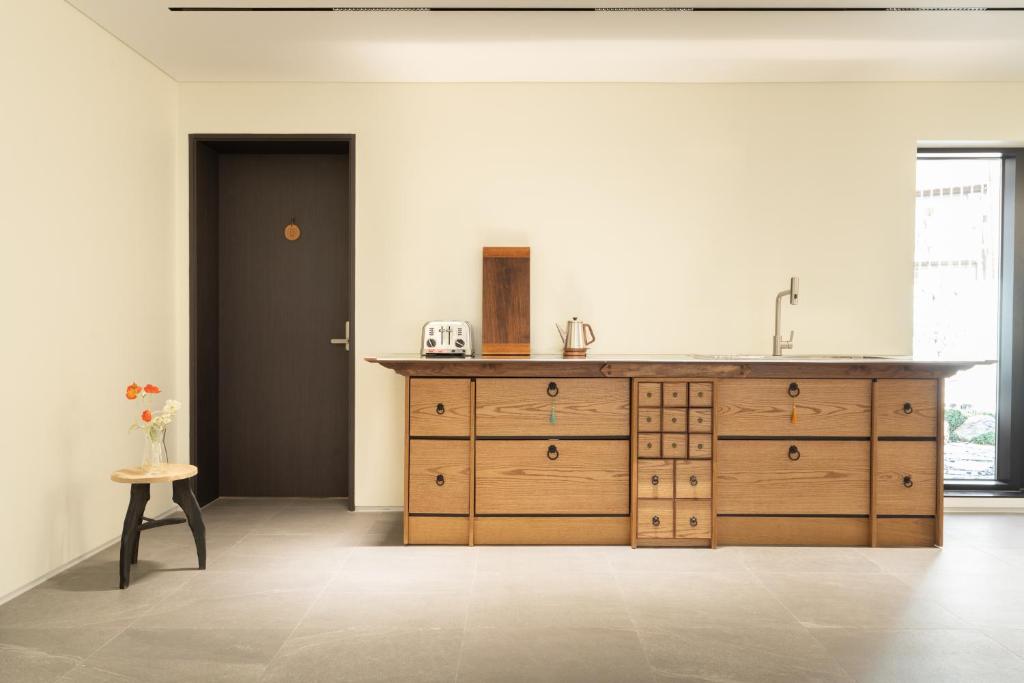 首尔Boro Hanok Hostel in Myeongdong的一个带水槽和木柜的厨房