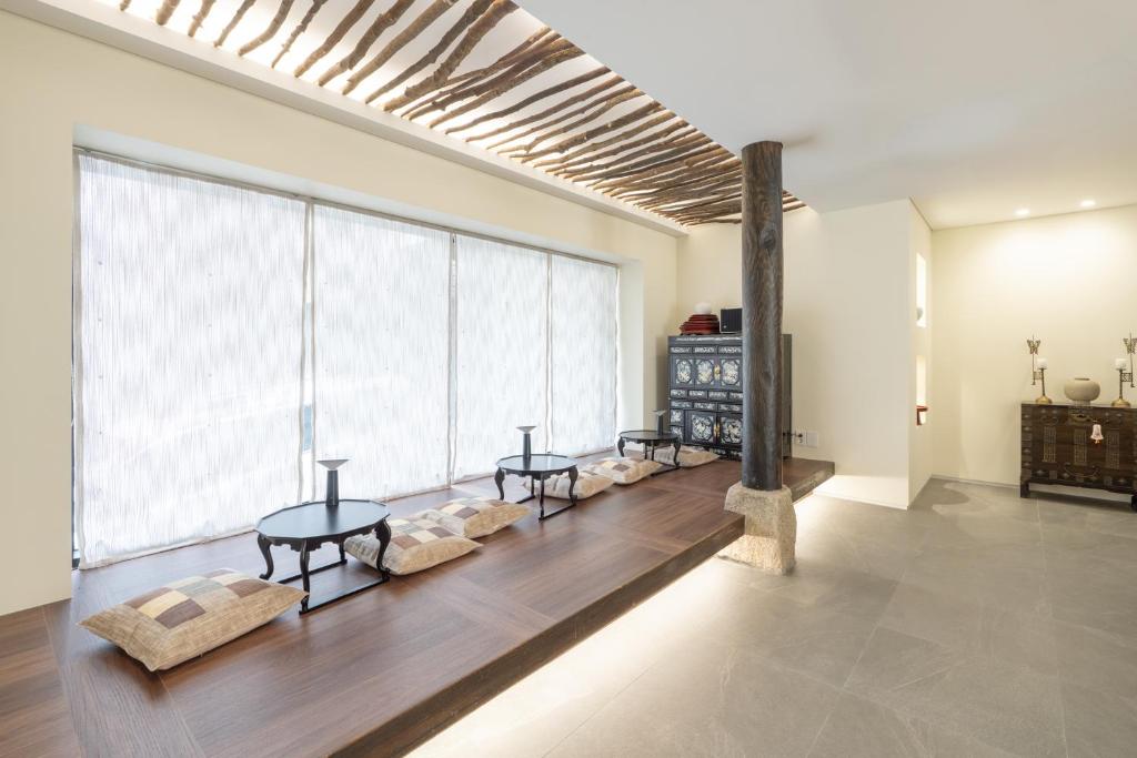 首尔Boro Hanok Hostel in Myeongdong的客厅设有两张桌子和大窗户