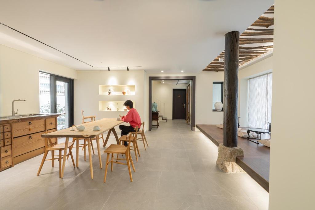 首尔Boro Hanok Hostel in Myeongdong的坐在厨房桌子上的人