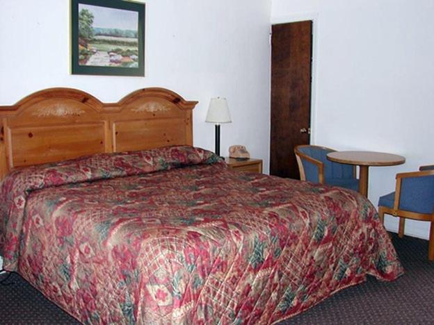 Morgantown摩根镇红地毯旅店&套房酒店的酒店客房带一张床、一张桌子和椅子