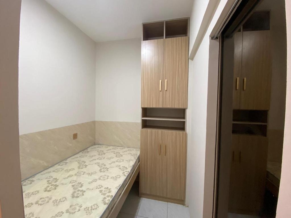 迪拜Garden Residence的小房间设有一张床和木制橱柜
