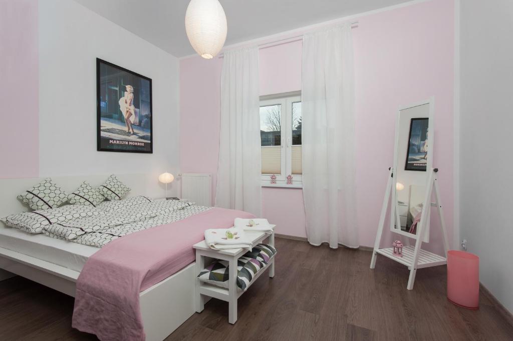 达洛科Iva Mare的白色卧室配有粉红色的床和一张桌子