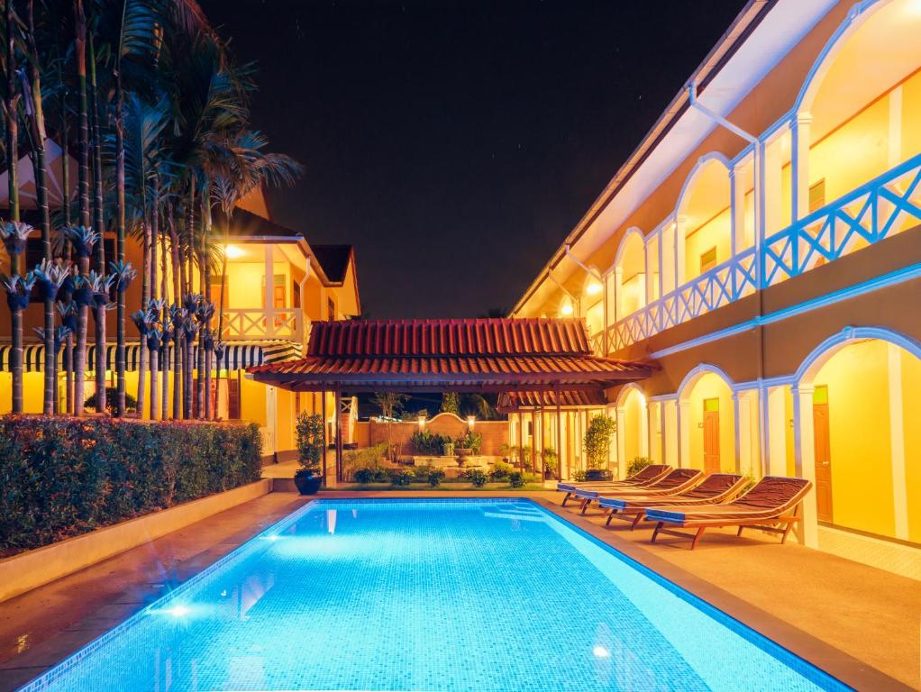 巴色花园酒店的夜间在房子前面的游泳池