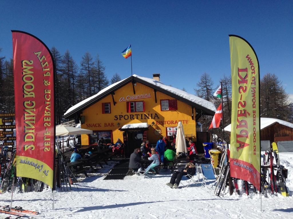 萨奥兹-杜尔克斯Chalet Capannina的滑雪小屋前雪中一组旗帜
