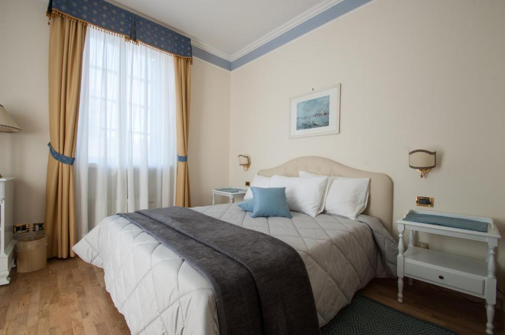 格拉多埃里卡别墅酒店的一间卧室设有一张大床和一个窗户。