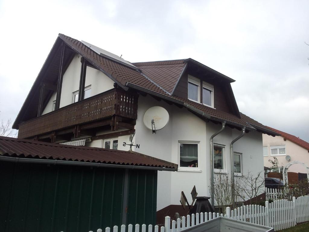 茨魏布肯FERIENHAUS FISCHER的白色的房子,有棕色的屋顶和栅栏
