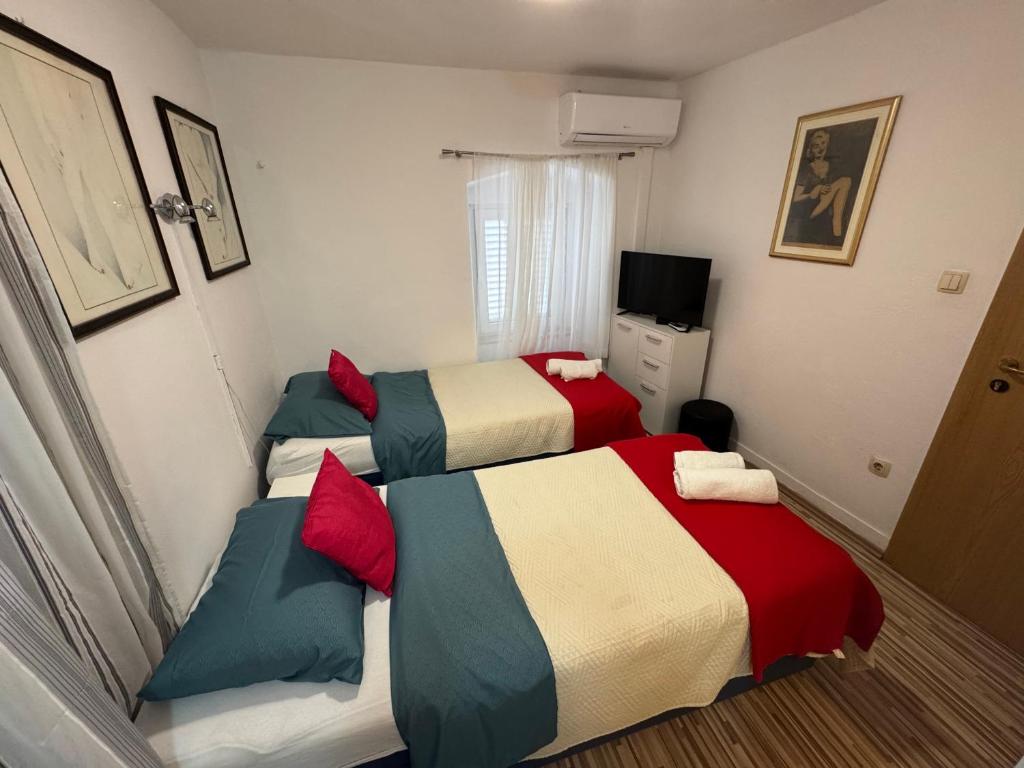 斯普利特达米拉客房旅馆的一间卧室配有两张床和电视