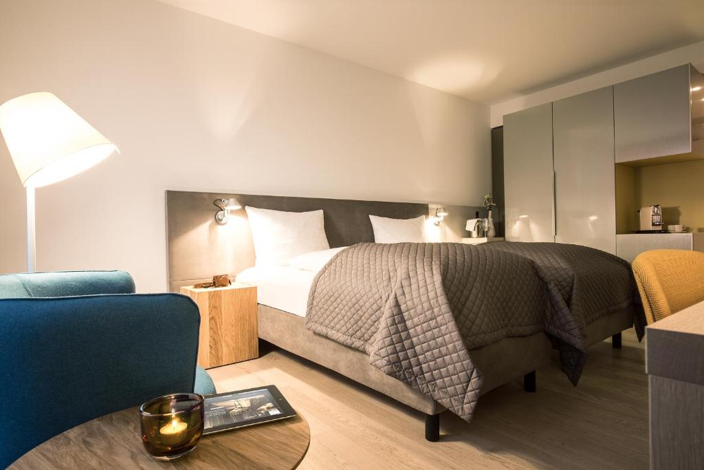 朗道因德普法尔茨兰道马克西米利精品酒店的卧室配有1张床、1张桌子和1把椅子