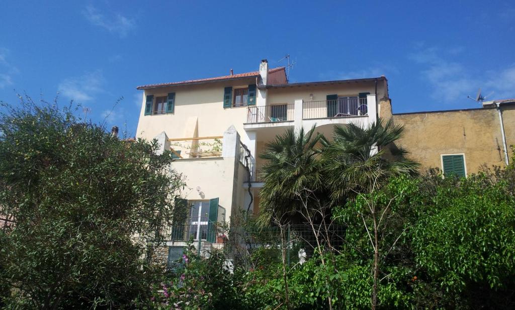 圣巴特罗摩艾美尔Il Poggio di Poiolo的一座白色的建筑,前面有棕榈树