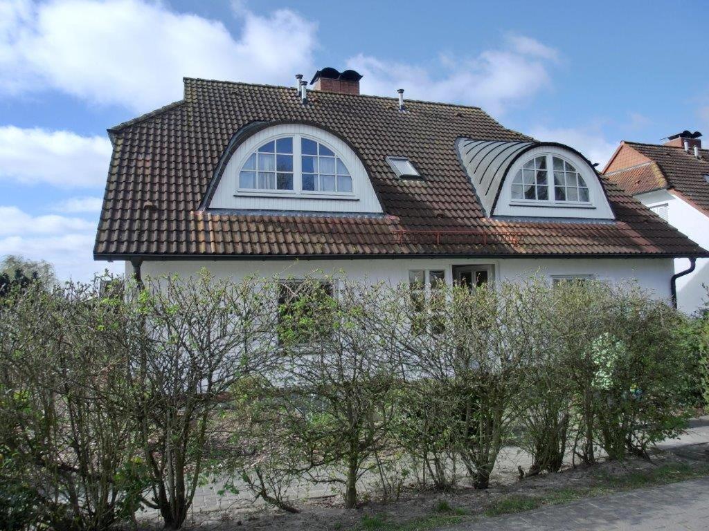 岑平艾特尔瓦斯尔布里克公寓的白色的房子,有棕色的屋顶和一些树木
